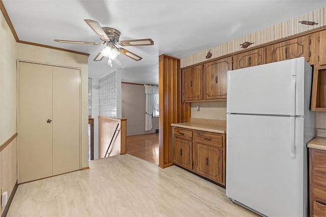 kitchen featuring ceiling fan, white refrigerator, light wood-type flooring, and ornamental molding