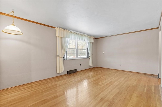 spare room with light wood-type flooring and ornamental molding