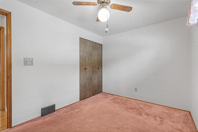 unfurnished bedroom featuring ceiling fan, carpet floors, and a closet