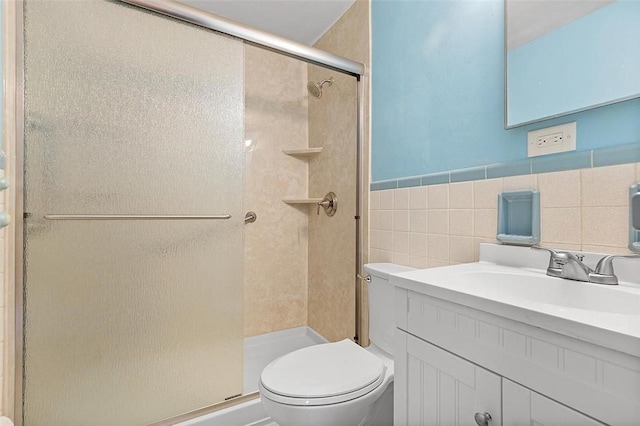 bathroom featuring an enclosed shower, vanity, toilet, and tile walls