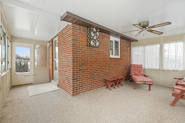 unfurnished sunroom with ceiling fan