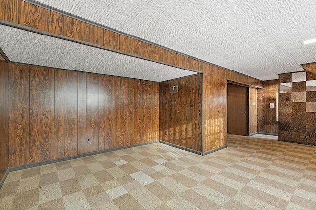 carpeted spare room with wood walls