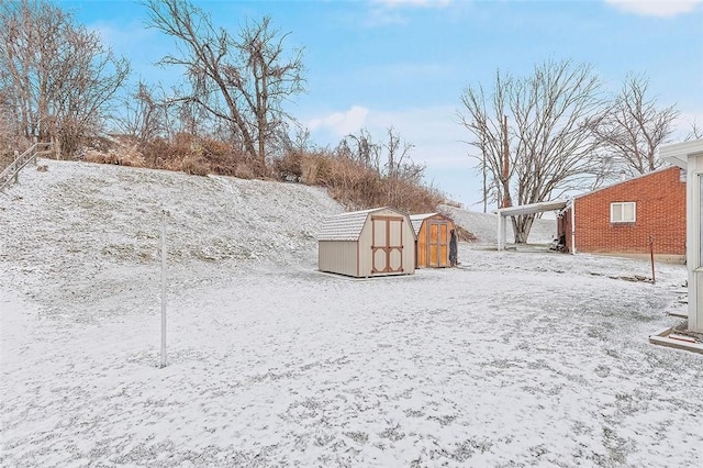 yard layered in snow featuring a shed