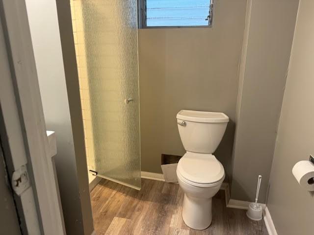 bathroom with toilet and wood-type flooring