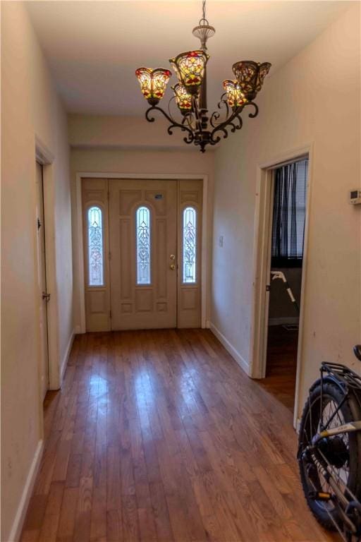 entryway featuring hardwood / wood-style flooring and a notable chandelier