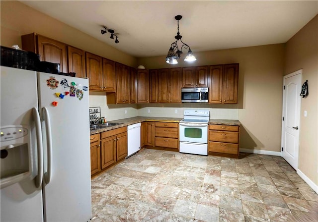 kitchen featuring a chandelier, sink, hanging light fixtures, and white appliances