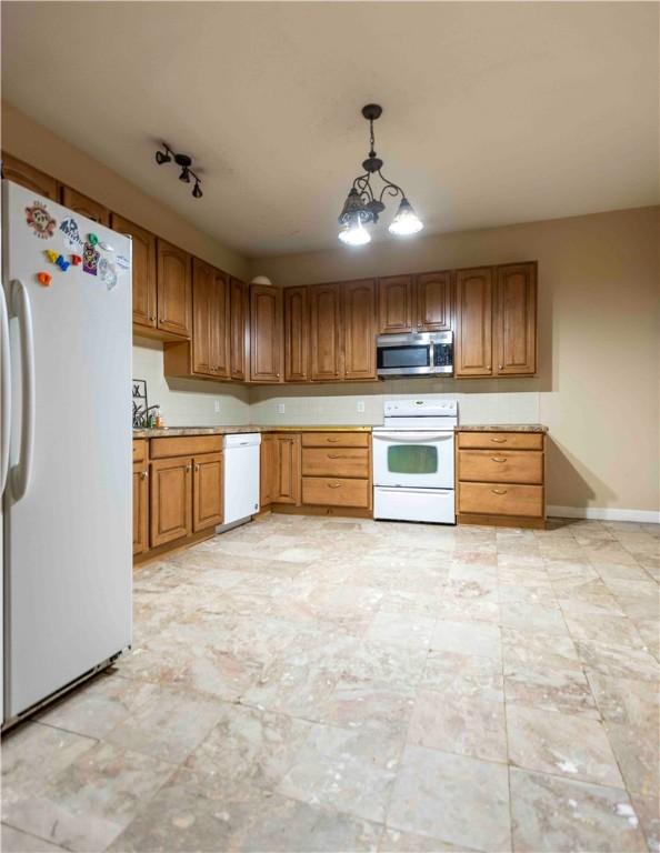 kitchen featuring pendant lighting, white appliances, and an inviting chandelier