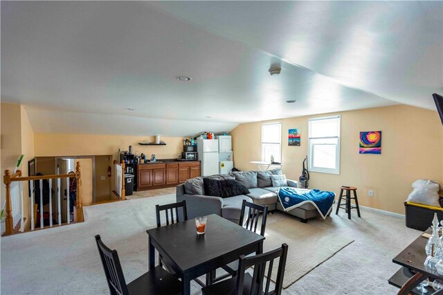 carpeted dining room featuring lofted ceiling