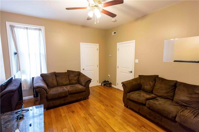 living room featuring light hardwood / wood-style floors and ceiling fan