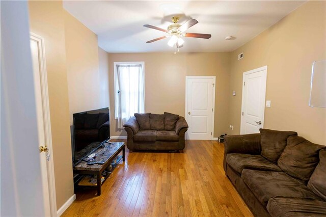 living room with ceiling fan and light hardwood / wood-style floors