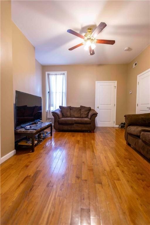 living room with ceiling fan and light hardwood / wood-style flooring