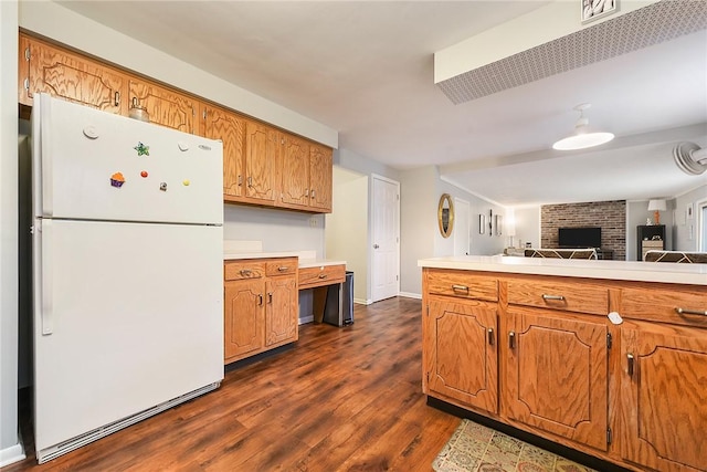 kitchen with white refrigerator, kitchen peninsula, and dark wood-type flooring