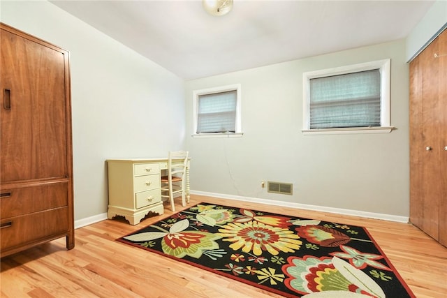 bedroom with multiple windows and light hardwood / wood-style floors