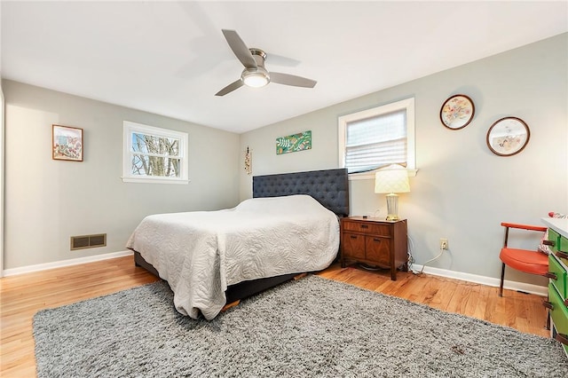 bedroom featuring light hardwood / wood-style floors, multiple windows, and ceiling fan