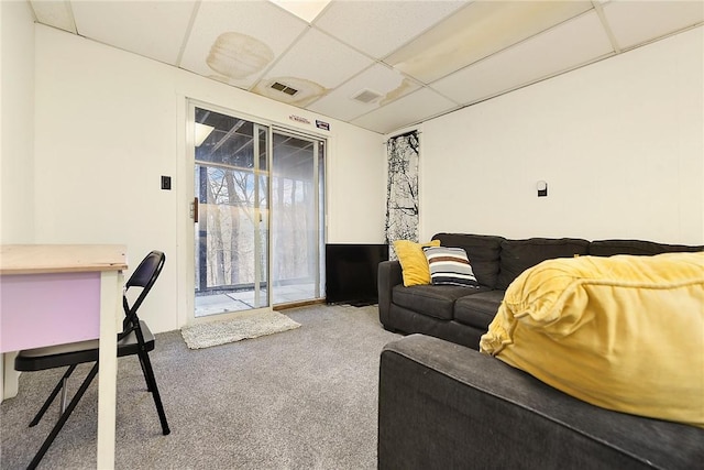 carpeted living room with a drop ceiling