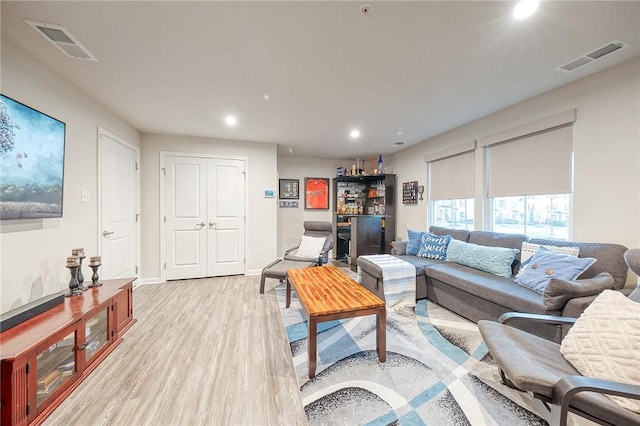 living room featuring light wood-type flooring and bar area