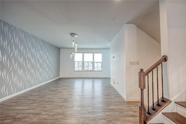 unfurnished room with a textured ceiling and hardwood / wood-style flooring