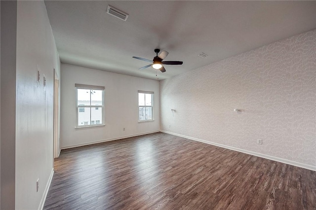 unfurnished room with ceiling fan and dark hardwood / wood-style flooring