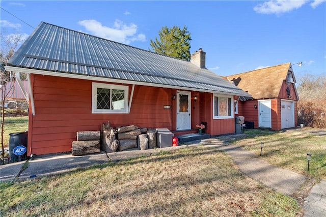 view of front of property with an outbuilding, a front lawn, and a garage