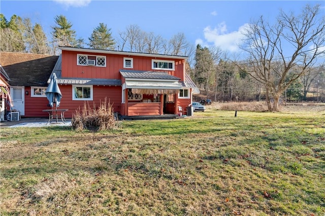 rear view of property featuring cooling unit, a patio area, and a lawn