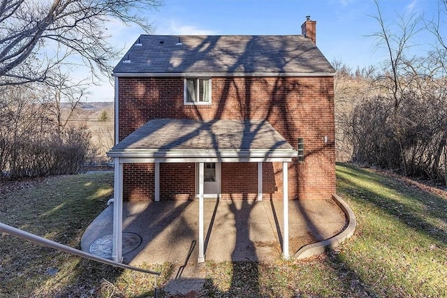 rear view of house with a lawn and a patio