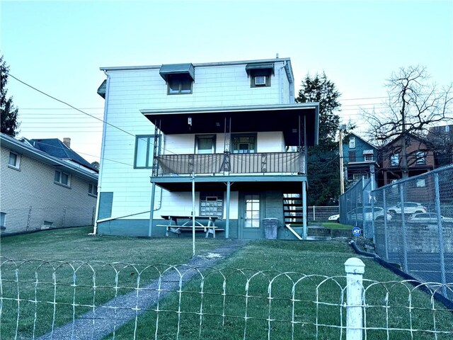 back of house with a yard and a balcony