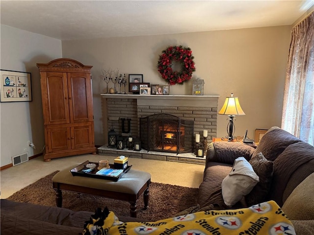 carpeted living room with a stone fireplace