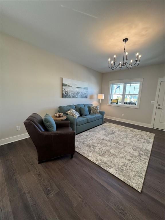 living area with dark wood-style flooring, baseboards, and an inviting chandelier