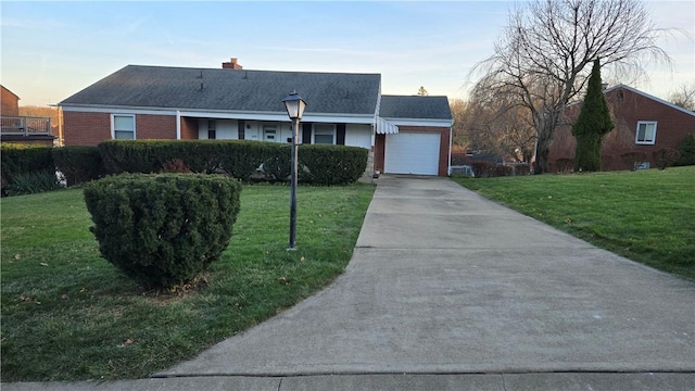 ranch-style home featuring a garage and a lawn