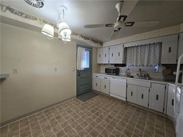 kitchen with white cabinetry, dishwasher, sink, hanging light fixtures, and a chandelier