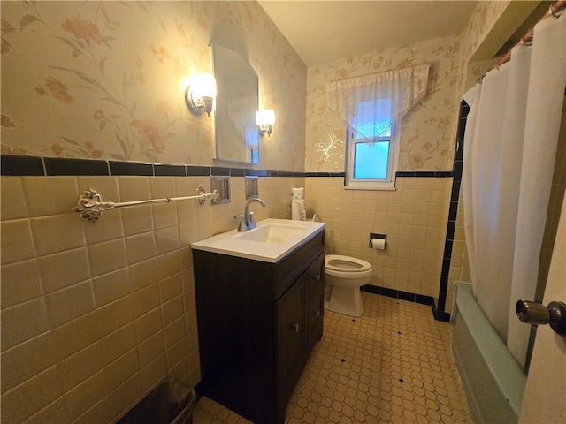 full bathroom featuring shower / tub combo, vanity, tile walls, and toilet