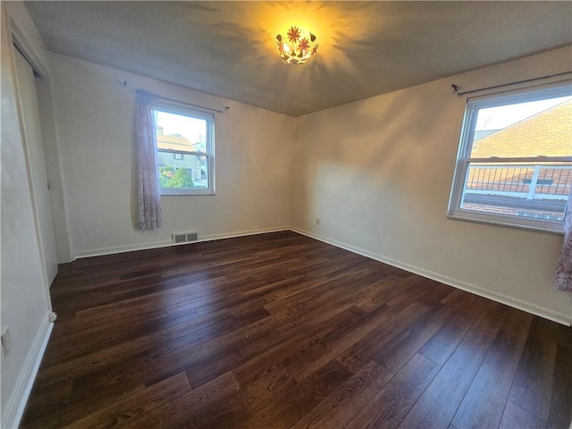 spare room featuring dark wood-type flooring