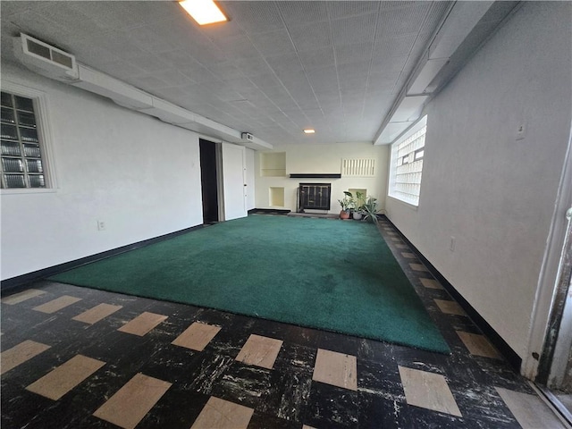 basement featuring dark carpet