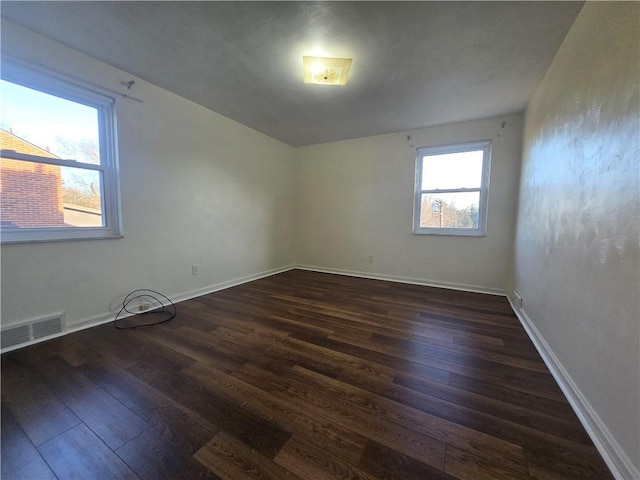 spare room featuring dark wood-type flooring