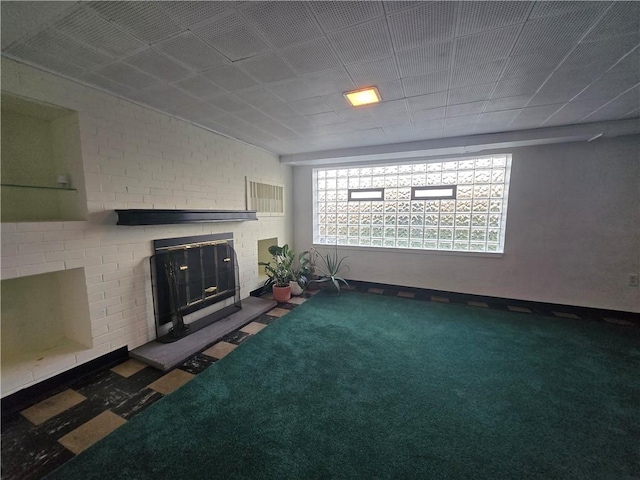 unfurnished living room featuring carpet flooring and a brick fireplace