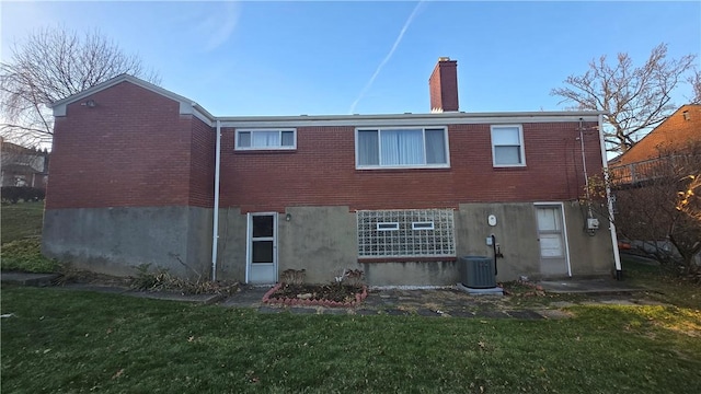 rear view of house featuring central AC and a yard