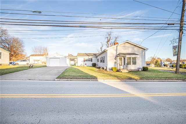 view of front of property featuring a front yard, an outbuilding, and a garage