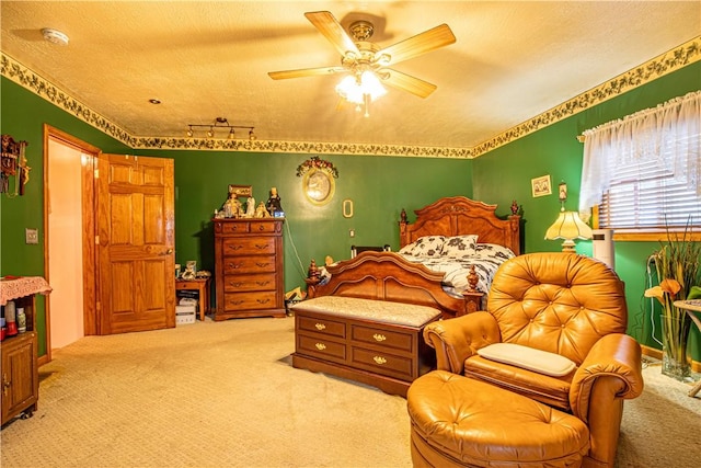 carpeted bedroom featuring ceiling fan and a textured ceiling