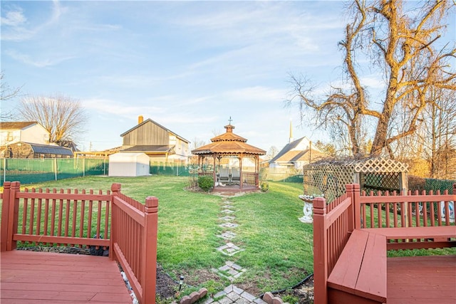 view of yard with a gazebo, a storage shed, and a deck