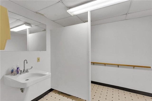 bathroom featuring a paneled ceiling and sink