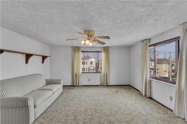 living room featuring ceiling fan, light colored carpet, and a textured ceiling