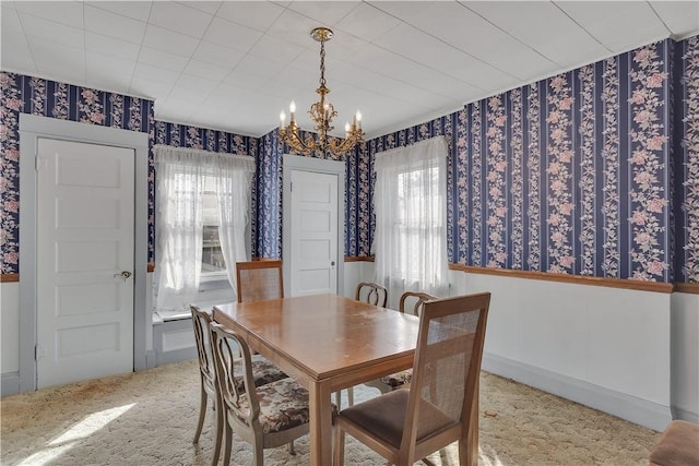 carpeted dining space with a notable chandelier