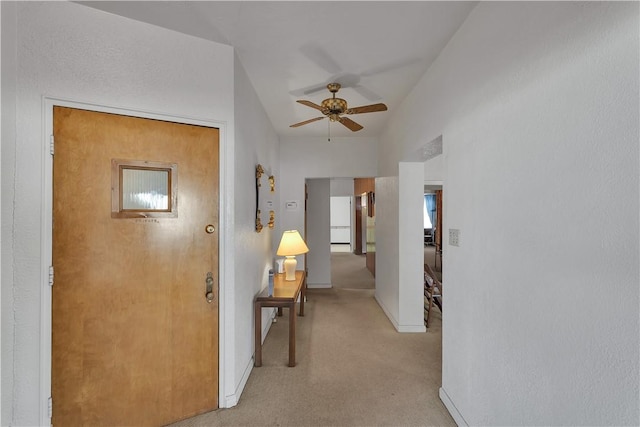 corridor featuring light colored carpet and vaulted ceiling