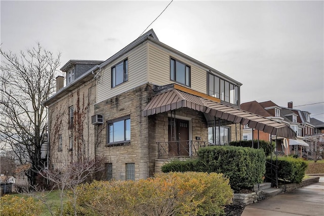 view of front of home featuring an AC wall unit