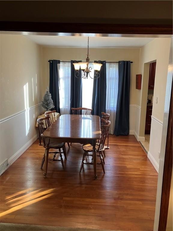 dining area featuring a chandelier and wood-type flooring