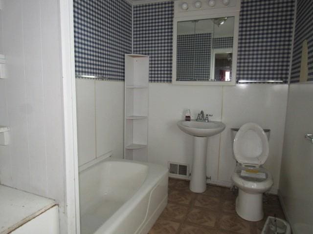 bathroom with parquet flooring, toilet, and sink