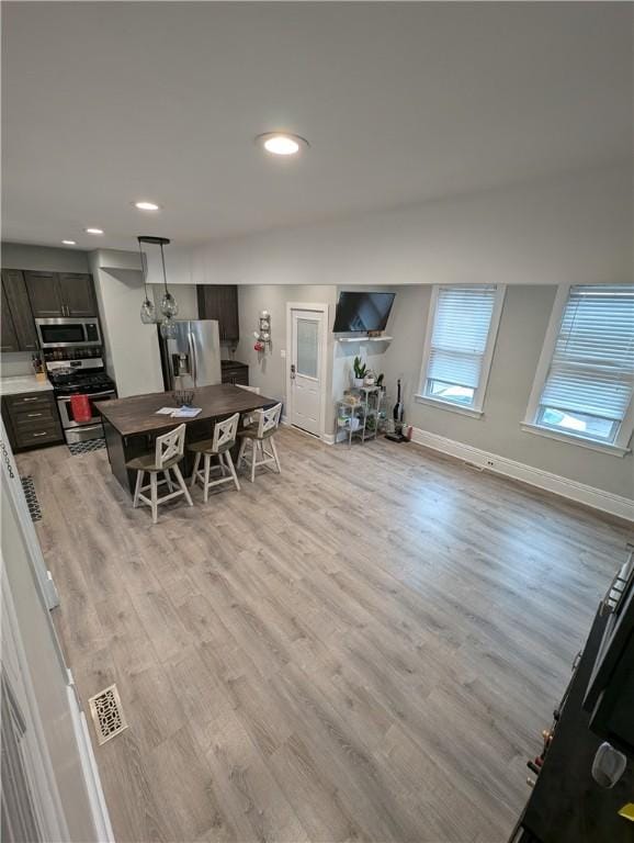 dining space with lofted ceiling and light wood-type flooring