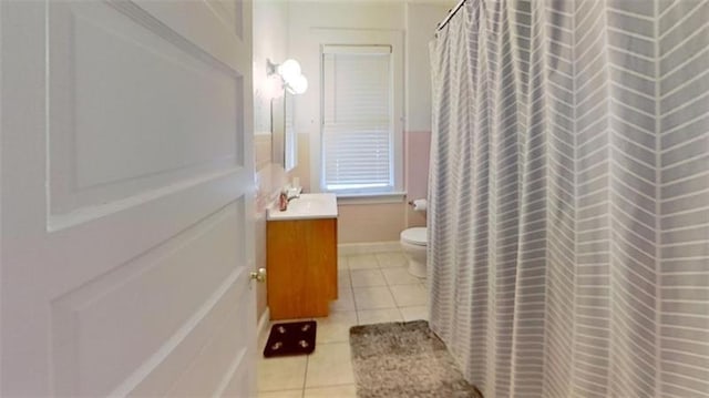 bathroom with tile patterned flooring, vanity, toilet, and walk in shower