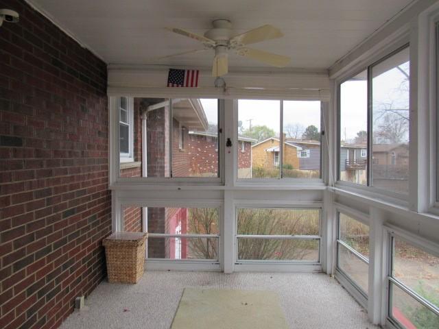 unfurnished sunroom with plenty of natural light and ceiling fan