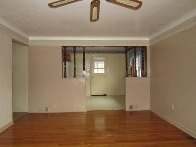 spare room featuring ceiling fan, crown molding, and wood-type flooring